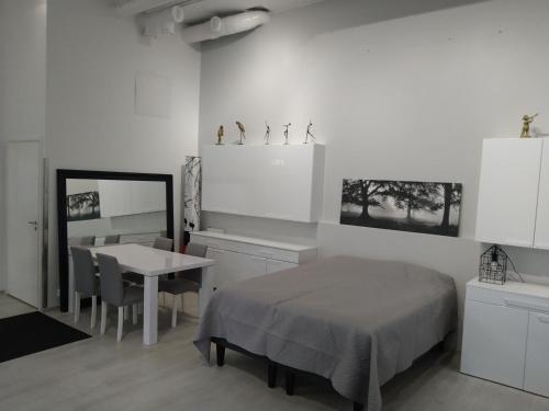 een slaapkamer met een bed, een tafel en een spiegel bij Apartment Satama in Kuopio