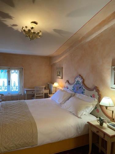 1 dormitorio con 1 cama blanca grande y 2 mesas en Quattro Gigli Palace, en Montopoli in Val dʼArno