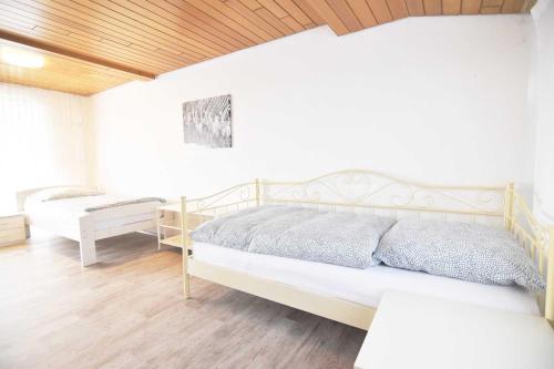 a white bedroom with a bed and a bench at Work & Stay in Sankt Augustin near Troisdorf in Sankt Augustin