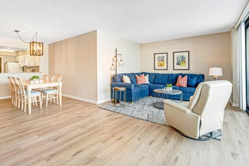 a living room with a blue couch and a table at Sea Colony - 302S Edgewater in Bethany Beach