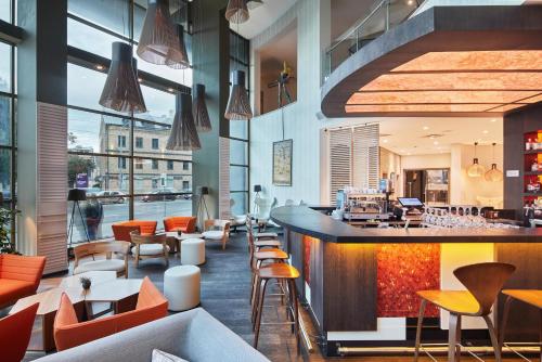 un ristorante con bar, tavoli e sedie di Holiday Inn Vilnius, an IHG Hotel a Vilnius