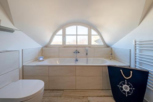 a bathroom with a tub and a toilet and a window at Meeresrauschen - a57674 in Kramerhof