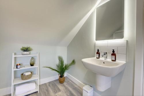 a white bathroom with a sink and a mirror at The Nook - A modern 2 bedroom loft with parking in Ripon