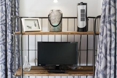 a television on a shelf in a room at Hawk's Nest in Wadebridge