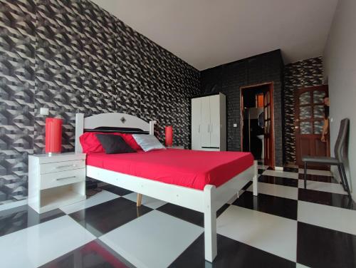 a bedroom with a red bed and a black wall at Estrela do Mar - Beachfront in Vila do Maio