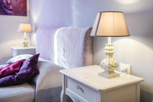 a lamp on a night stand next to a bed at Le Rêve - Lake view rooms in Sirmione