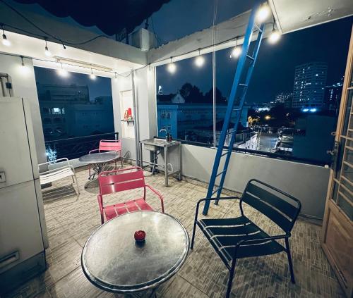 a room with chairs and a table and a ladder at Alleyway Hostel in Ho Chi Minh City