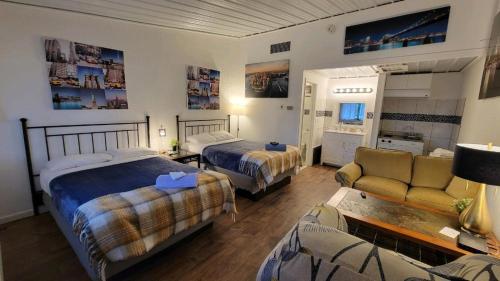 ein Hotelzimmer mit 2 Betten und einem Sofa in der Unterkunft Sussex Motel in Wantage