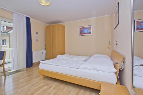 a bedroom with a bed and a chair in it at Balkon, gratis Nutzung vom AHOI Erlebnisbad und Sauna in Sellin - Appartemenmt Nordwind in Baabe