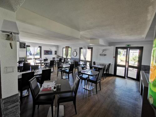 une salle à manger avec des tables et des chaises dans un restaurant dans l'établissement Hôtel Inn Design Resto Novo Langres, à Langres