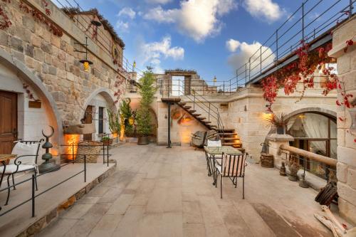 a courtyard with chairs and tables in a building at The Rupestral House Hotel in Uchisar