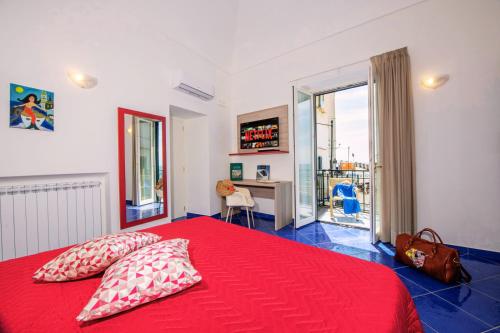 a bedroom with a red bed with two pillows at Maison Escher in Atrani