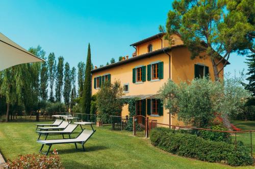 a group of benches in front of a building at Agriturismo Il Borgo in Cortona