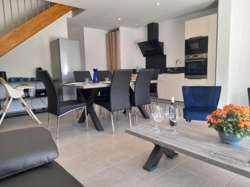 une salle à manger avec une table et des chaises et une cuisine dans l'établissement Gîte les gentianes Fleurs des Pyrénées, à Argelès-Gazost