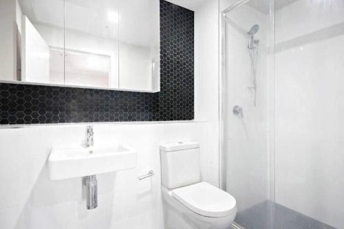 a bathroom with a toilet and a sink and a shower at Entire apartment with lake view in Tuggeranong