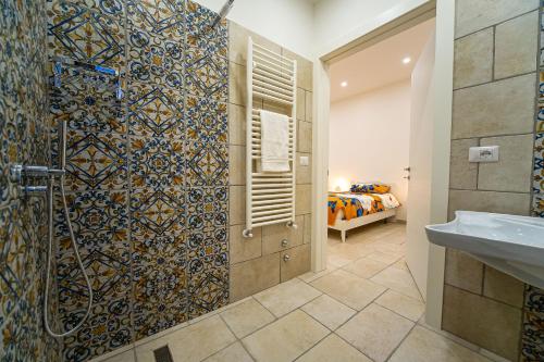 a bathroom with a shower with a mosaic wall at Irpinia BikeHouse in Montella