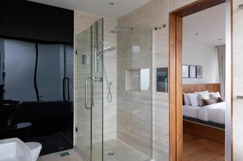 uma casa de banho com uma cabina de duche em vidro e uma cama. em The Canary Wharf Secret - Glamorous 3BDR Flat with Terrace and Parking em Londres