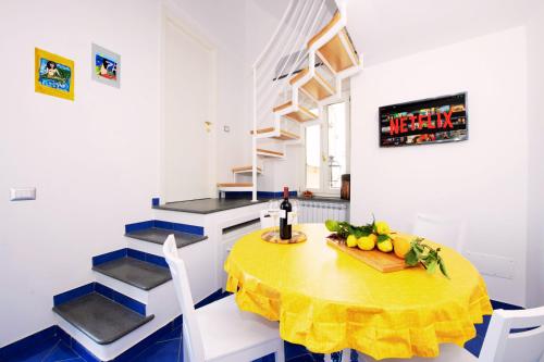a kitchen with a table with a bowl of fruit on it at Maison Escher in Atrani
