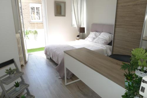 1 dormitorio con cama y escritorio. en Logement Place d'Erlon hypercentre avec balcon, en Reims