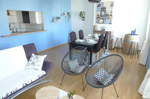 a living room with a table and chairs at Logement Place d'Erlon hypercentre avec balcon in Reims