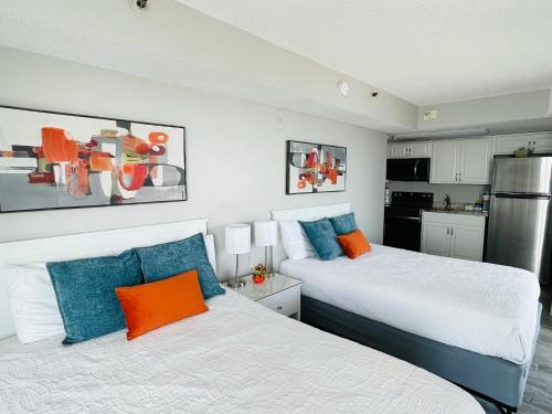 two beds in a room with a kitchen at 1726 Ocean View Galore Pet Friendly in Myrtle Beach