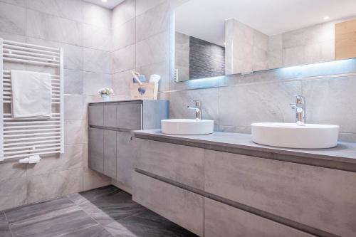 ein Badezimmer mit 2 Waschbecken und einem Spiegel in der Unterkunft Alpenappart App Weiße Zinne in Steinhaus