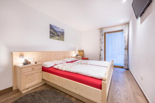 Schlafzimmer mit einem Bett und einem Fenster in der Unterkunft Alpenappart App Weiße Zinne in Steinhaus