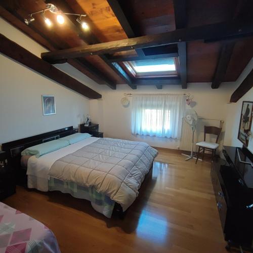 a bedroom with a large bed and a wooden floor at Casa Zanier Aviano in San Martino