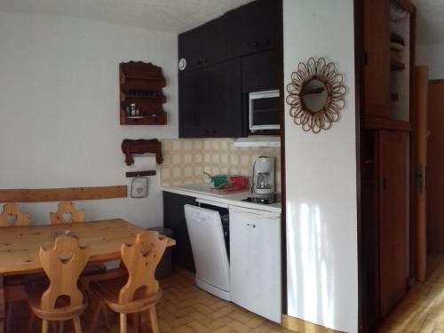 a small kitchen with a wooden table and a table and chairs at Appartement Valloire, 2 pièces, 4 personnes - FR-1-263-139 in Valloire