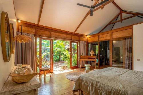 a bedroom with a bed in a room with glass doors at Secret River Villa - Luxury Villa 5 Bedrooms - Kerobokan - Canggu in Kerobokan