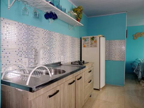 Een keuken of kitchenette bij Stúdio inteiro em casa familiar-ar cond próx praia