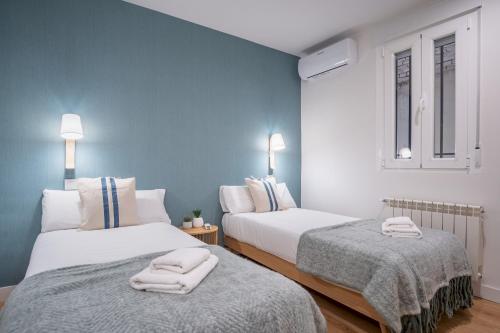 two beds in a room with blue walls at 2 bedrooms 2 bathrooms furnished - Retiro - stylish - MintyStay in Madrid