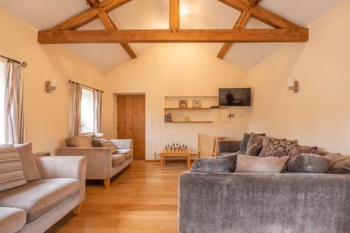 a living room with two couches and a table at The Stables in Bromyard
