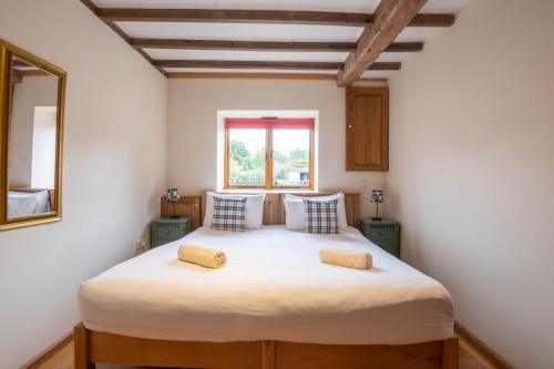 a bedroom with a large bed with two pillows at The Stables in Bromyard