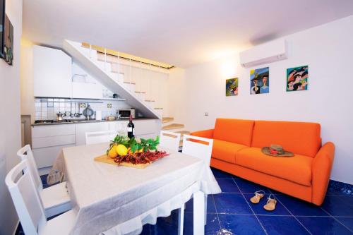 un soggiorno con tavolo e divano arancione di Maison Escher ad Atrani