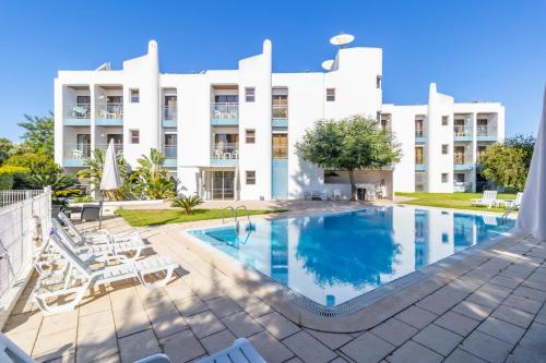 a swimming pool in front of a building at ZARCO - Apartment in Vilamoura with 2 Pools near the Beach & the Marina in Quarteira
