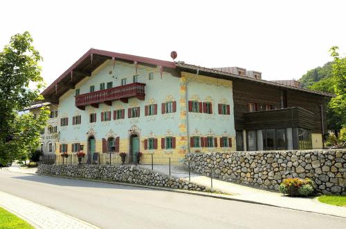 a large building with a stone wall in front of it at Seebacher Haus in Oberaudorf