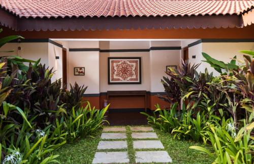 a walkway to the front of a house at Denissons Beach Resort, formerly Gamyam Retreat in Kumta