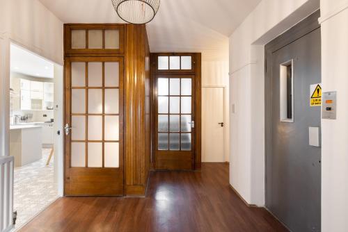 a hallway with a wooden door and wooden floors at The West End Penthouse - 4BDR with Views in London