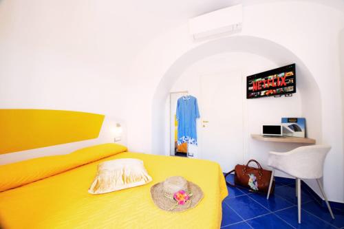 a bedroom with a yellow bed with a hat on it at Maison Escher in Atrani