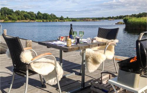 a table with two chairs and a bottle of wine at 3 Bedroom Lovely Home In Ronneby in Ronneby