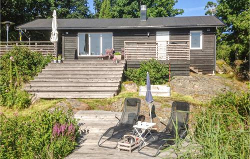 a house with two chairs and a table and an umbrella at 3 Bedroom Lovely Home In Ronneby in Ronneby