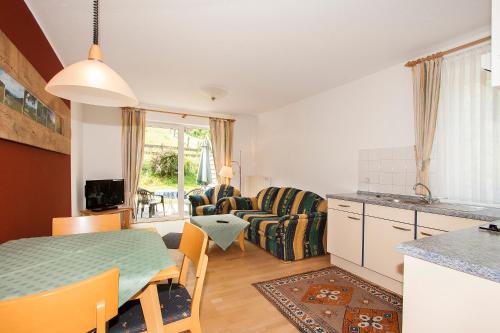 eine Küche und ein Wohnzimmer mit einem Tisch in der Unterkunft Hotel Gut Vorwald in Schmallenberg