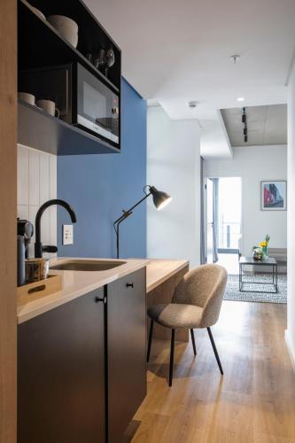 a kitchen with a sink and a desk and a chair at Home Suite Hotels Station House in Cape Town