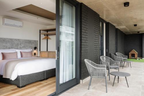 a bedroom with a bed and a patio with chairs at Home Suite Hotels Station House in Cape Town