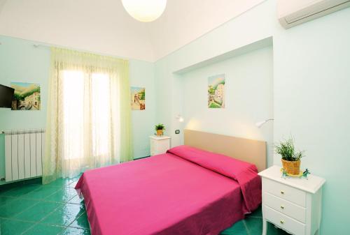 アマルフィにあるDomus Florio Coralloのベッドルーム1室(ピンクベッド1台、窓付)