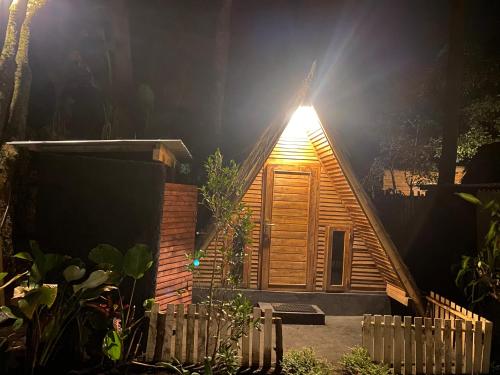 a small wooden cabin with a light on the roof at Triangle House and hot spring in Kintamani