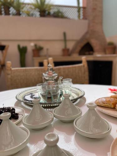 a table with a white table cloth with plates and dishes at Riad Gasämbre Touareg in Marrakech