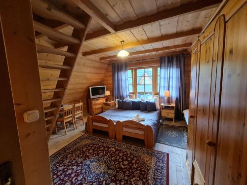 una camera con un letto in una baita di tronchi di GliczarowSki u Zbója a Zakopane