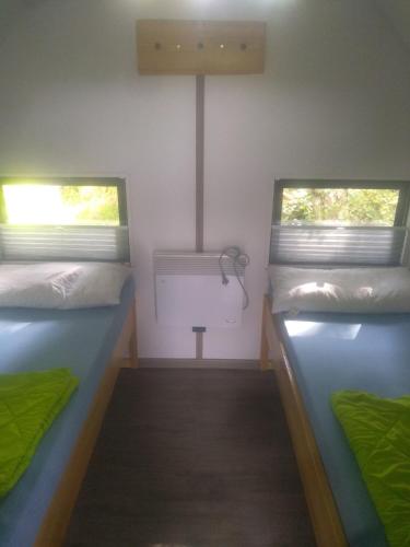 two beds in a small room with a sink at Fehnkate in Papenburg